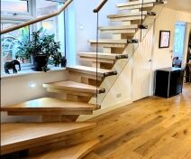 Polished Oak Staircase with Central Stringer, Glass Banister and Continuous Handrail